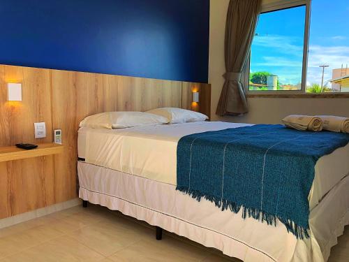 1 dormitorio con 1 cama grande y pared azul en Pousada Brisa do Mar en Aquiraz