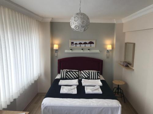 Schlafzimmer mit einem Bett mit schwarzen und weißen Kissen in der Unterkunft Goji's Apartments in Istanbul