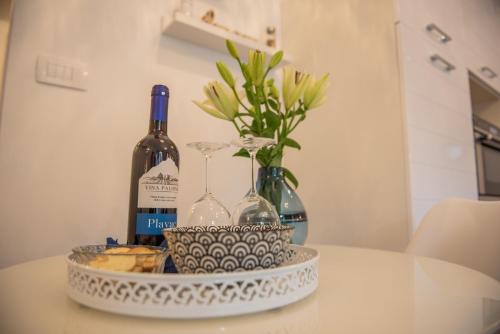 a bottle of wine and two glasses on a table at Marcel Zadar Old Town in Zadar