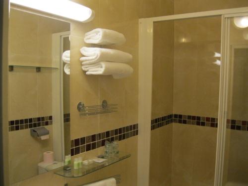 a bathroom with a stack of towels on a wall at Le Nouvel Hôtel du Théâtre in Paris