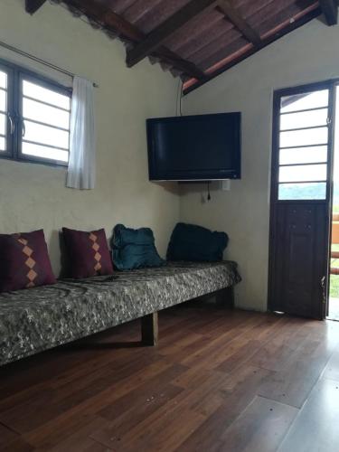 a couch in a room with a flat screen tv at Cabaña El Salto in Cuetzalán del Progreso