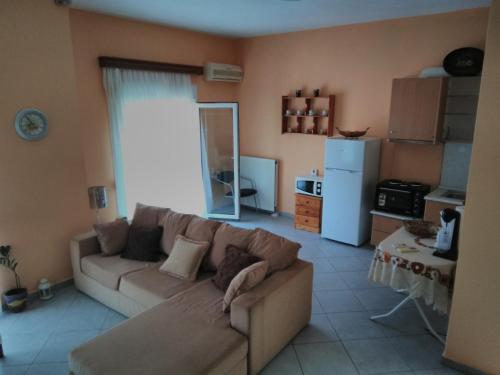 Stavroula في Melissátika: غرفة معيشة مع أريكة ومطبخ