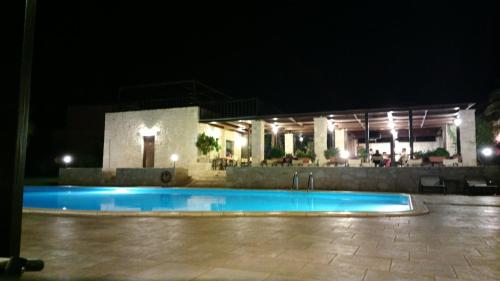 a swimming pool in front of a building at night at Kallicrates Village in Frangokastello