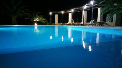 a large blue swimming pool at night with lights at Kallicrates Village in Frangokastello
