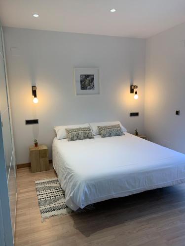 a bedroom with a large white bed with two pillows at Apartamento Somos Ainsa in Aínsa