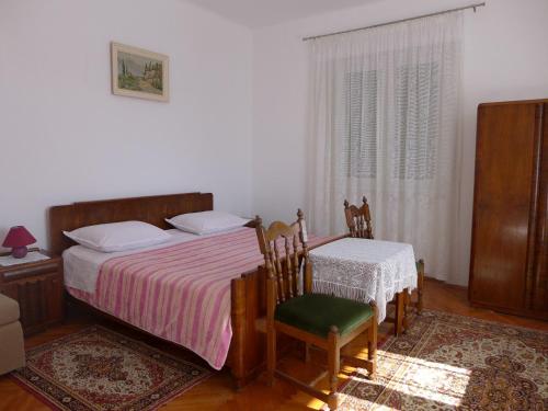 um quarto com uma cama, uma mesa e cadeiras em Apartment Mari - 30 m from sea em Sumartin