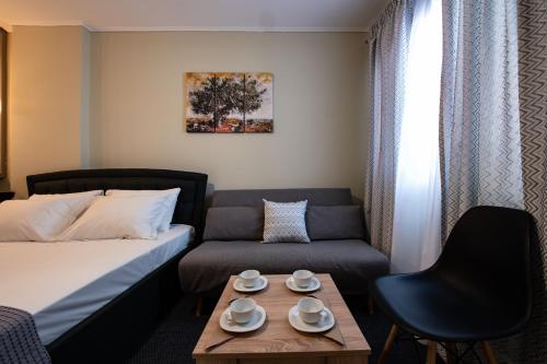 Cette chambre comprend un lit, un canapé et une table. dans l'établissement Olive House, à Ioannina