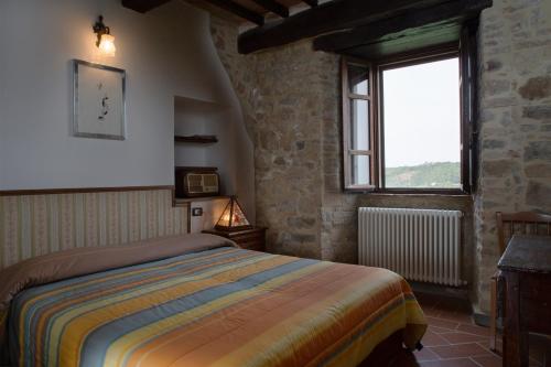 a bedroom with a bed and a window at Castello Di Cisterna in Gualdo Cattaneo