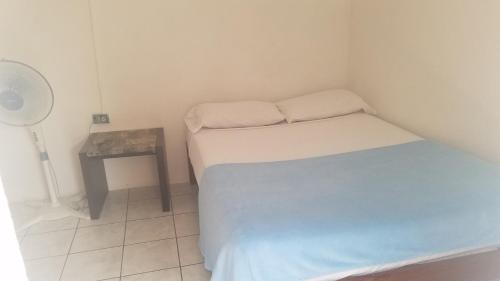 Habitación pequeña con cama y mesita de noche en Luna International Hostel, en Estelí