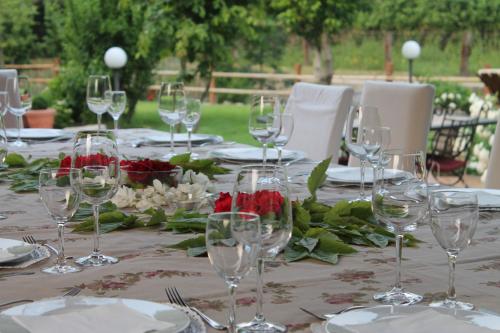 a table with wine glasses and roses on it at Hotel Calvi-Ristorante Mainor in Vittorio Veneto
