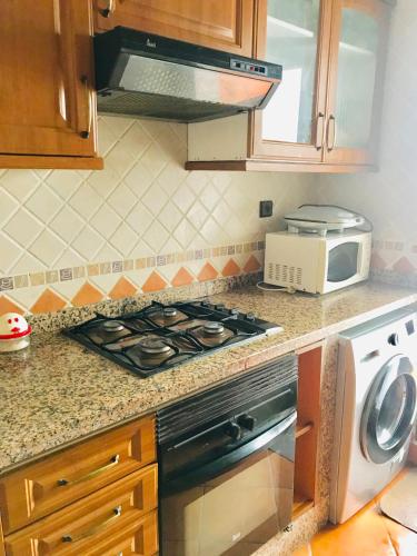 a kitchen with a stove and a microwave at Marina beach appartement, M'diq Ave, Tetouan in Tetouan