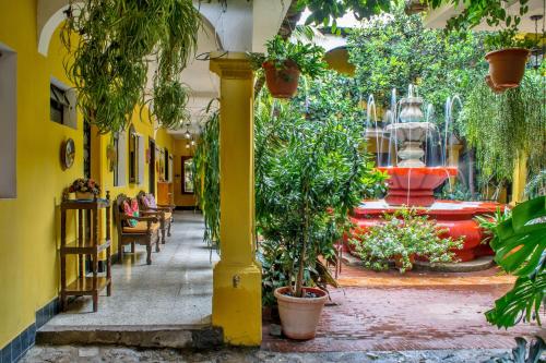 a hallway with plants and a fountain in a building at Posada San Vicente by AHS in Antigua Guatemala