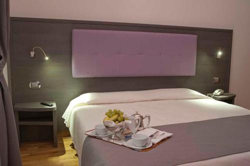 a hotel room with a bed with a tray of food at Hotel Settentrionale Esplanade in Montecatini Terme