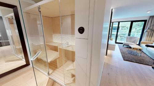 a glass shower in a room with a couch at White Pearl Apartment 1.04 in Timmendorfer Strand