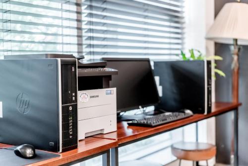 a desk with three computer monitors and a keyboard at Hotel Atrium Jongno in Seoul