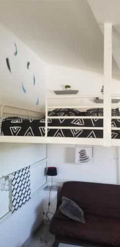 - une chambre avec 2 lits superposés dotés de draps noirs et blancs dans l'établissement studio 2, à Saint-Martin-la-Plaine