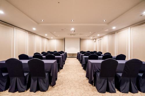 a conference room with tables and chairs and a screen at Hotel Atrium Jongno in Seoul