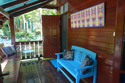 a blue bench on the porch of a house at Baan Kiao in Haad Yao