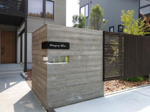 a concrete retaining wall with a sign on it at Shimogoryo House in Furano