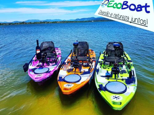 three kayaks are lined up in the water at POUSADA PARAÍSO DA LAGOA in Barra de Ibiraquera