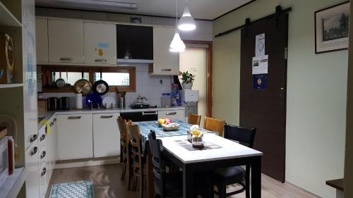a kitchen with a table and a table and chairs at Tongyeong Episode Guesthouse in Tongyeong