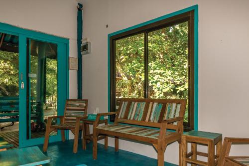 a room with two chairs and a window at Baan Kiao in Haad Yao