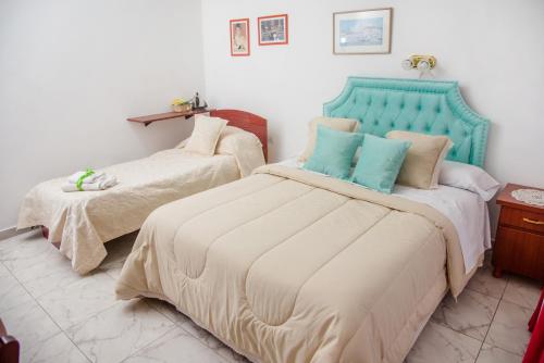 1 dormitorio con 2 camas y cabecero azul en Desayuno en Tiffany's en Arroyo Seco