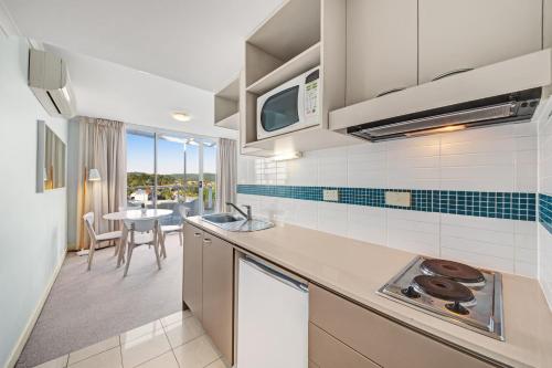 a kitchen with a sink and a counter top at Ettalong Beach Luxury Apartments in Ettalong Beach