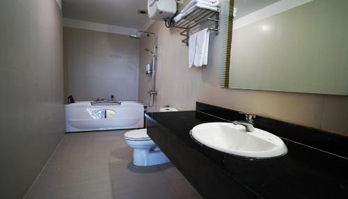 a bathroom with a sink and a toilet and a tub at Kim Long Hotel in Thái Bình