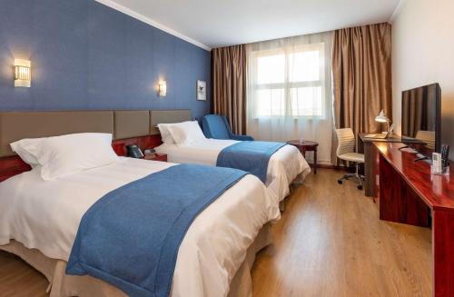 
a hotel room with two beds and a television at Best Western Estacion Central in Santiago

