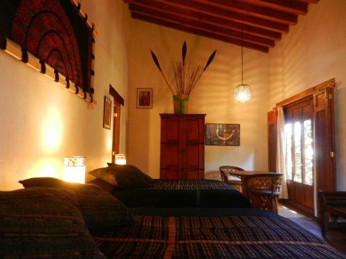 a bedroom with a bed and a table and a window at Posada Yolihuani in Pátzcuaro