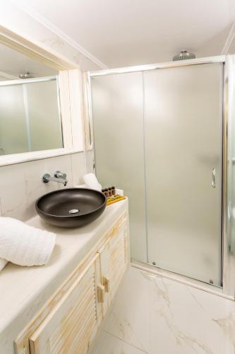 a bathroom with a sink and a glass shower at Rhodos Horizon City-Adults Only in Rhodes Town
