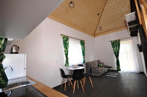 cocina y sala de estar con mesa y sillas en Apartamenty pod Skałą, en Polańczyk