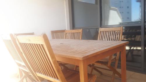 a wooden table and chairs with a wooden table and chairsktop at Apartment 2 bedrooms Central Location in Ashdod