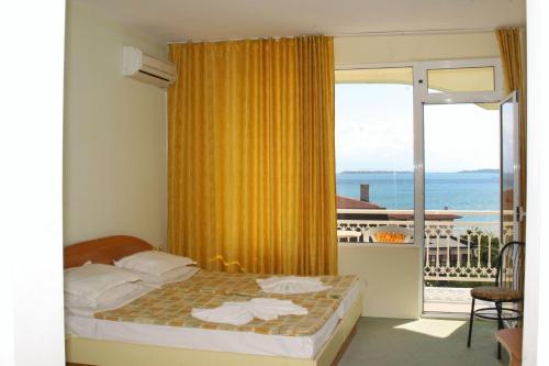 a bedroom with a bed and a view of the ocean at Hotel Panorama in Sveti Vlas