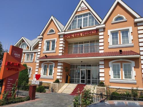 a building with a sign in front of it at Asia Hotel Fergana in Fergana