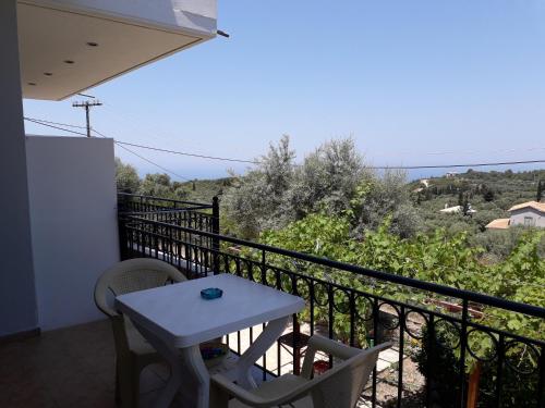 a table and chairs on a balcony with a view at Monika Lefkada in Tsoukaladhes