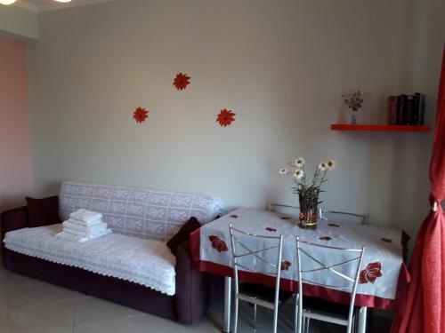 a living room with a couch and a table with flowers at Monika Lefkada in Tsoukaladhes