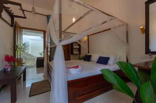 una camera con letto a baldacchino di Popoyo Surf Resort ad Arugam