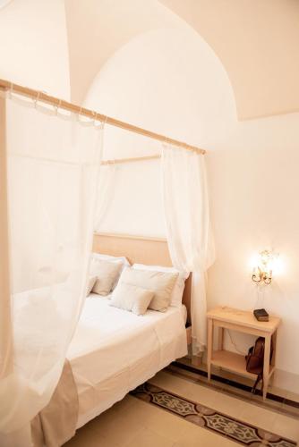 a bedroom with a bed with a mosquito net at Relais Masseria Villa Cenci in Cisternino