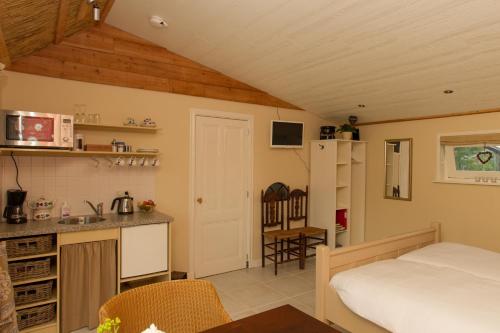 een slaapkamer met een bed en een keuken met een aanrecht bij Bed And Breakfast Rodenberg in Driebergen