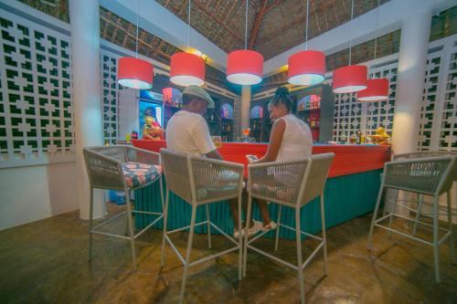 a man and a woman sitting at a bar at The ONE in Watamu