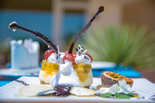 a dessert with fruit and whipped cream on a plate at The ONE in Watamu