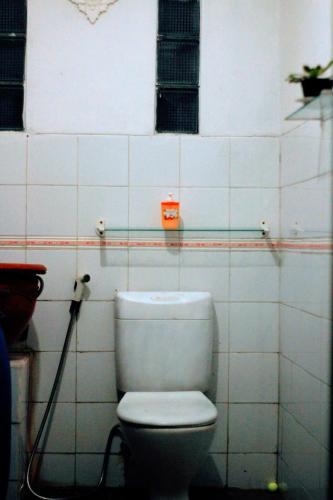 a bathroom with a white toilet in a room at Oemah Kajoe Lembang in Lembang