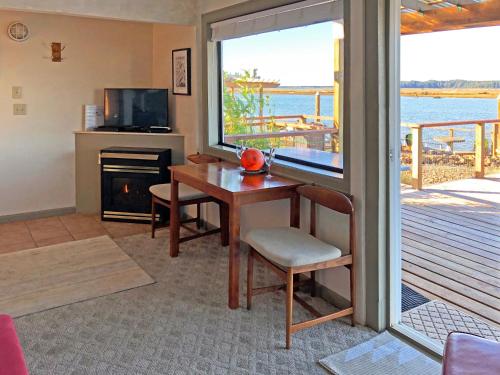 uma sala de estar com uma mesa e vista para o oceano em Wheeler on the Bay Lodge and Marina em Wheeler