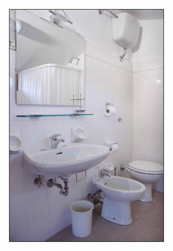 a bathroom with a sink and a toilet and a mirror at Due Torri in San Severino Marche