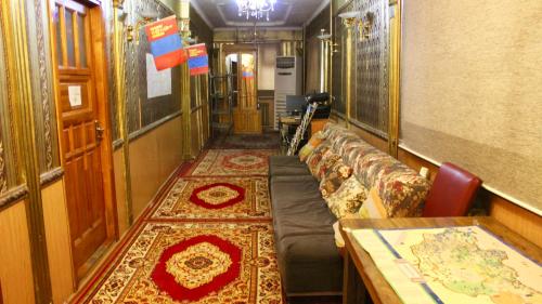 a train car with a couch and a table at City Hostel & Tours in Ulaanbaatar