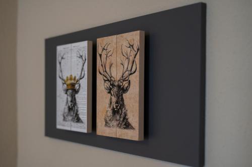 three framed pictures of deer on a wall at Hotel Hirsch in Kehl am Rhein