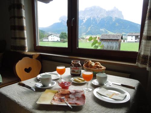 een tafel met een bord eten en drinken en een raam bij Haus Bergkranz in Lermoos