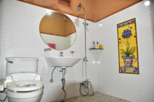 a bathroom with a toilet and a mirror at Golmangtae Pension in Boseong